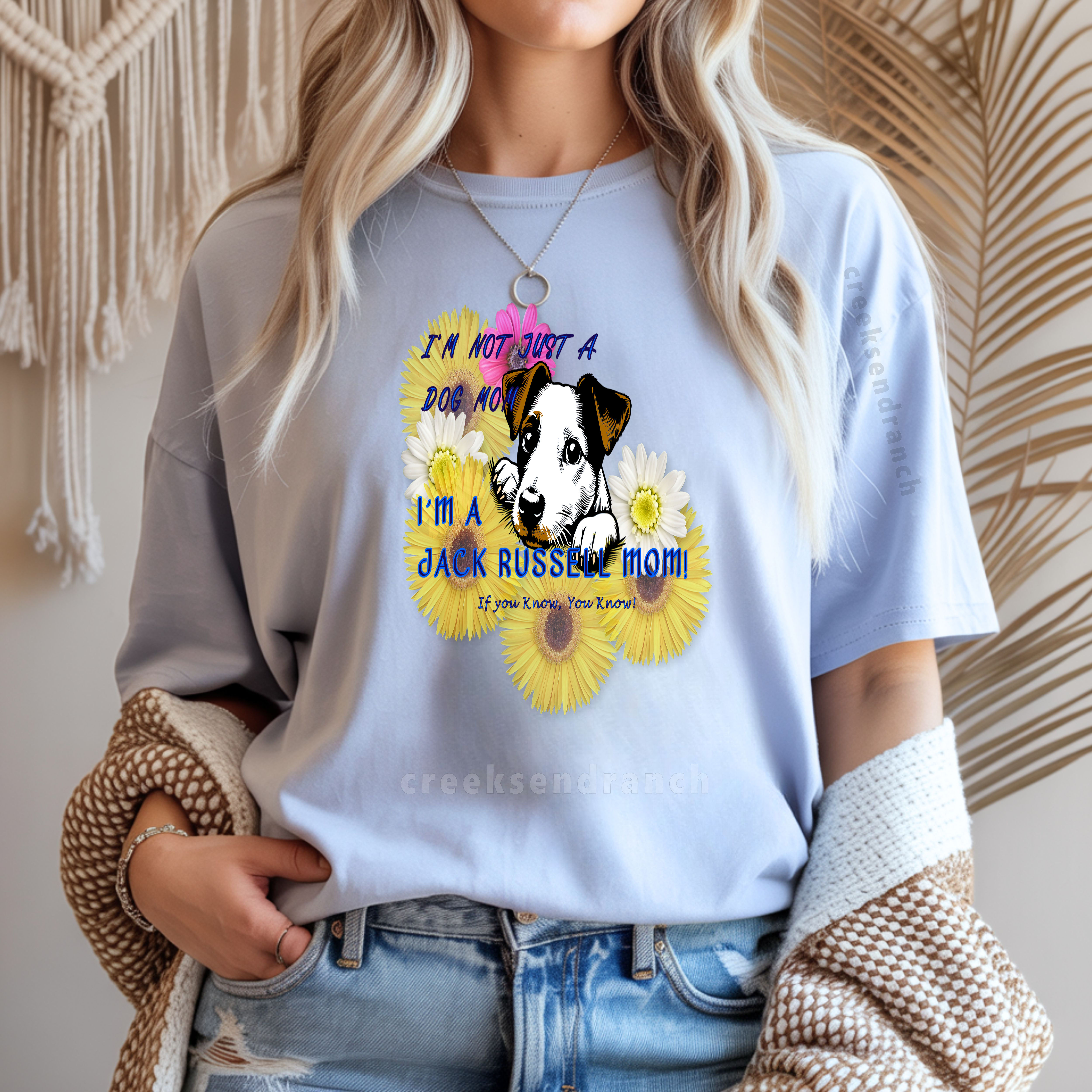 Person wearing a light blue T-shirt with a dog and sunflowers graphic that says 'I'm not just a dog mom'.